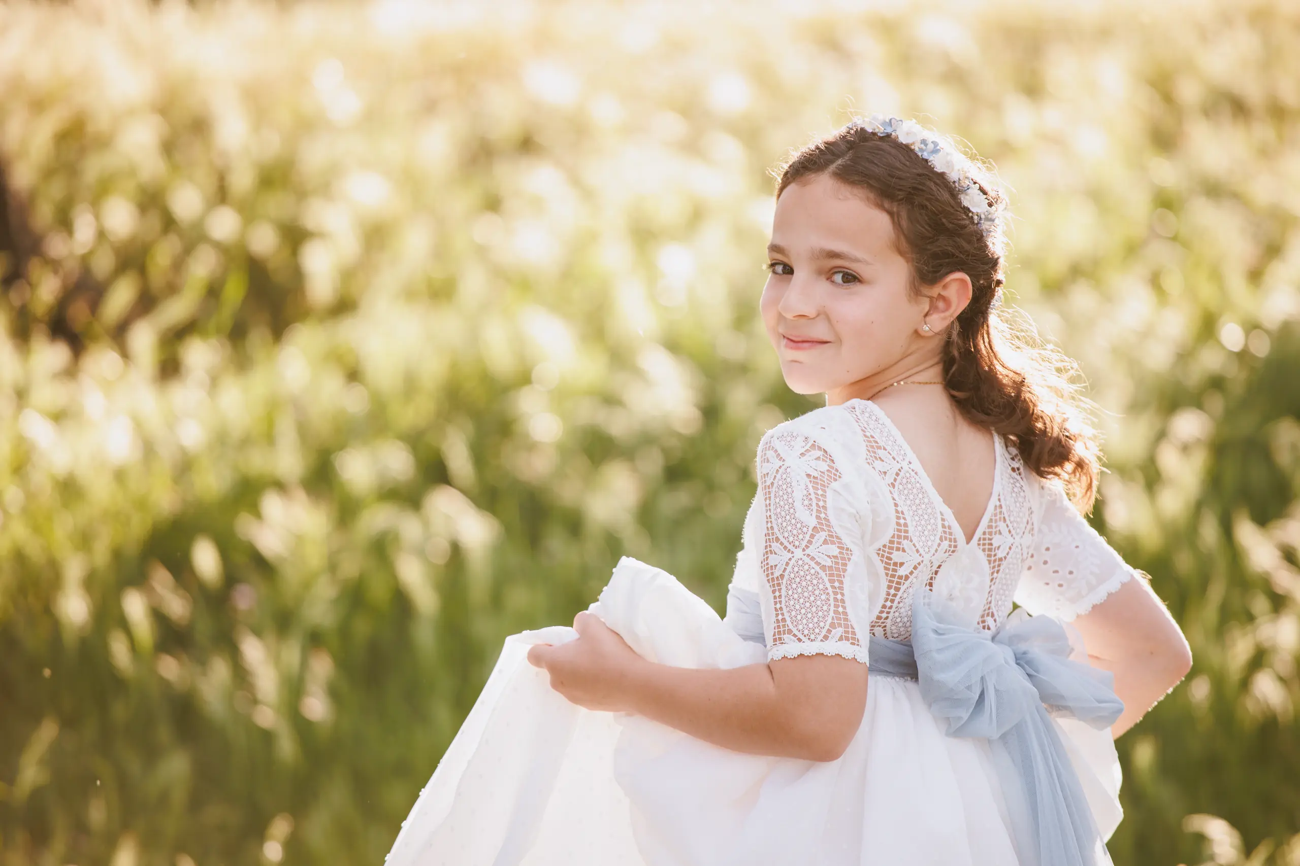 Niña vestida de comunión al atardecer