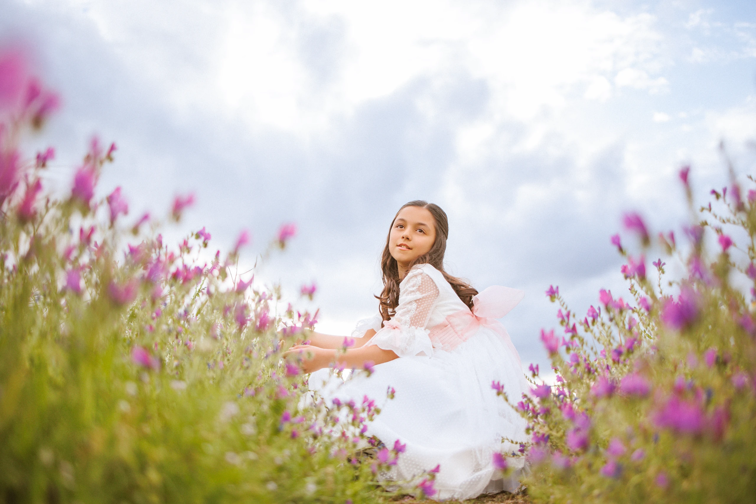 Niña de comunión entre flores silvestres